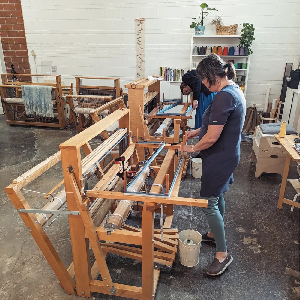 Students weaving on floor looms